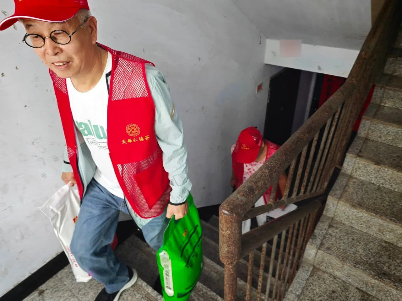 孙玉琴公益实践:志愿者将慰问物资搬运上楼。