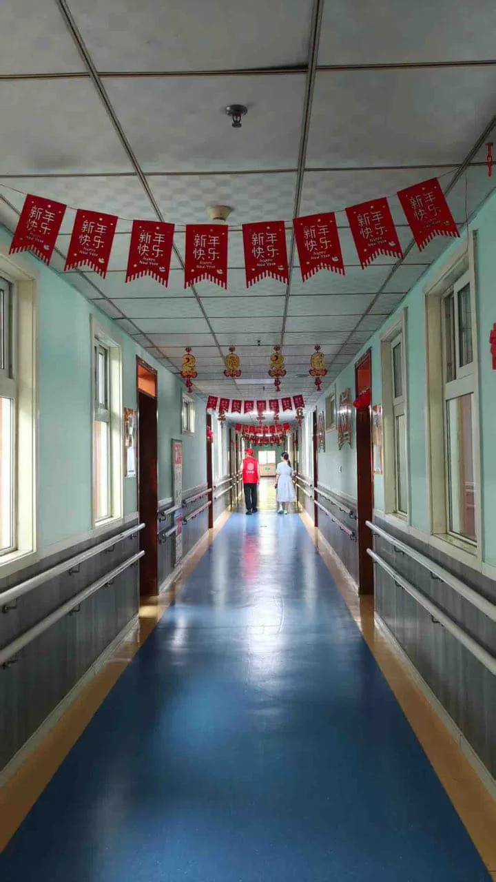 唐肖肖公益实践:院内走廊中的志愿者与工作人员背影。