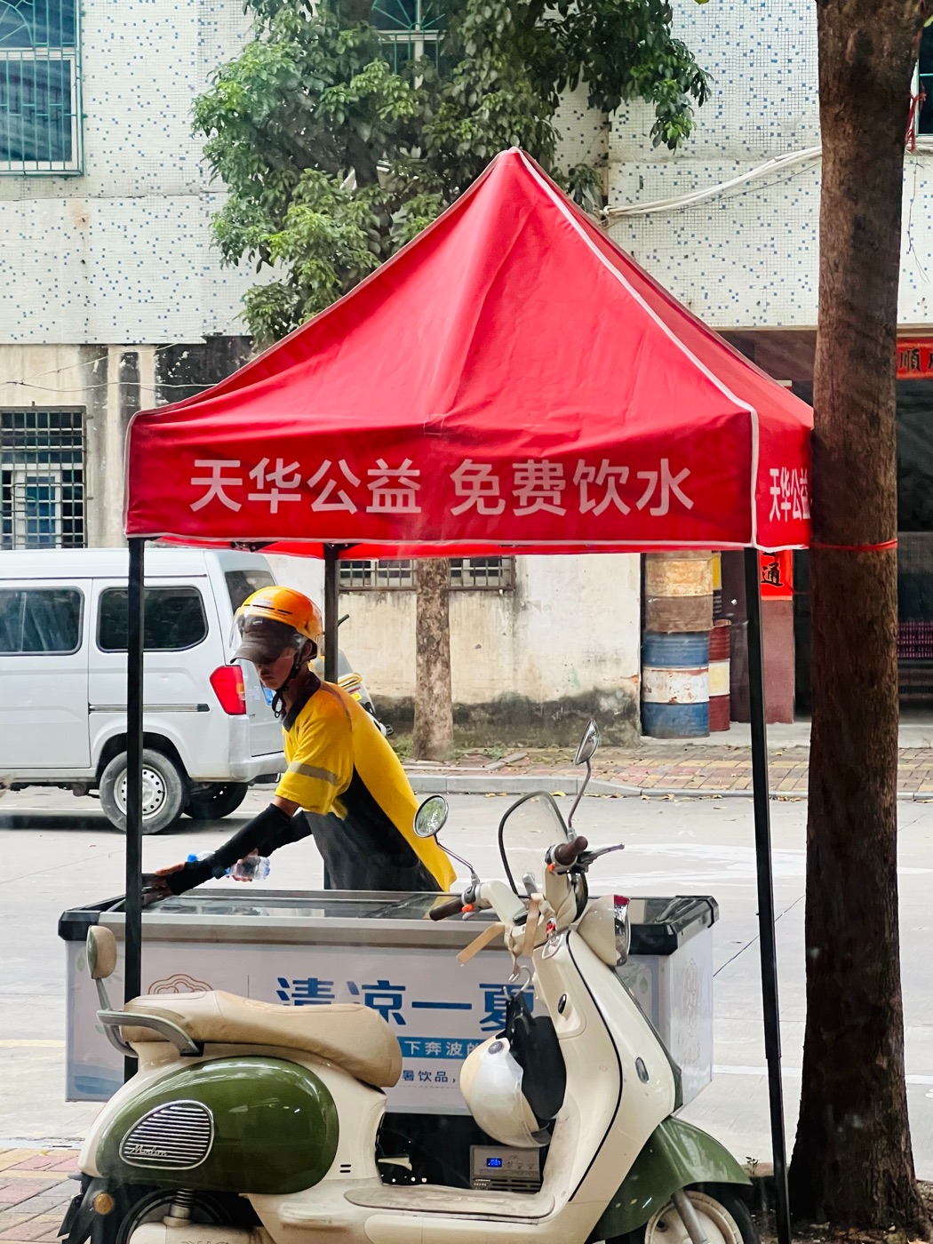 戴头盔的骑行者在免费饮水点领取瓶装水