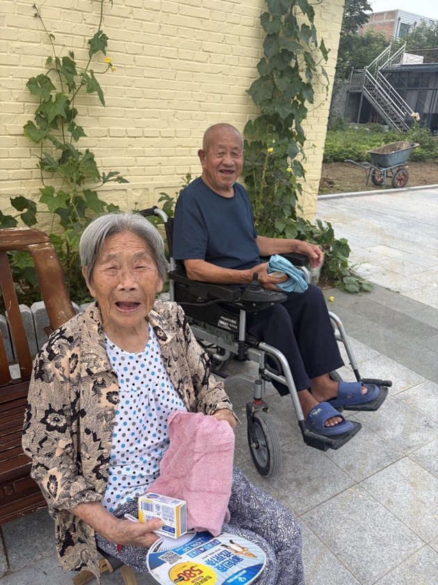 收到慰问品后微笑的养老服务中心长者