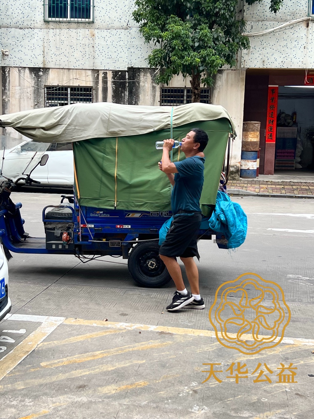 一位市民在路边饮用领取的瓶装水