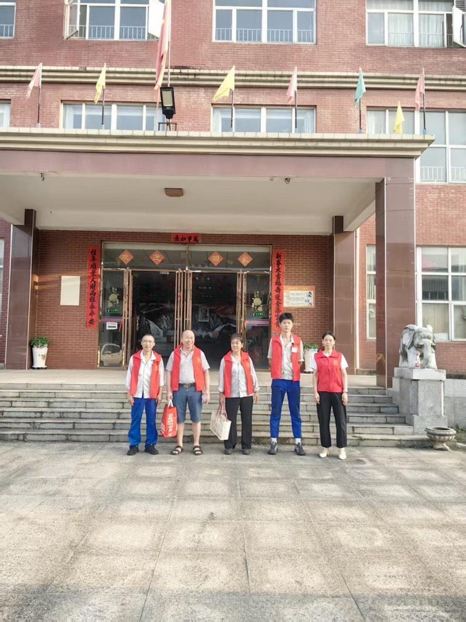 胡辉荣与4名伙伴在龙王社区老人院门前合影