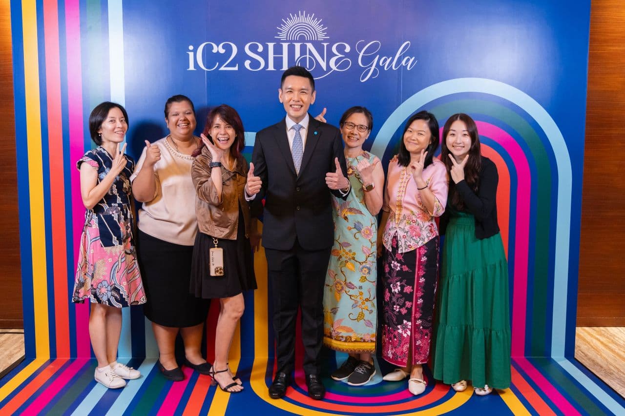 晚宴参与者在 iC2 SHINE Gala 背景板前微笑合影