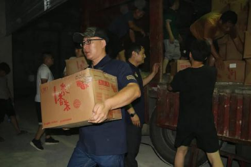 工作人员夜间搬运救援物资箱
