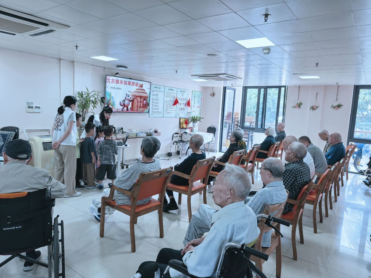 团队成员带着孩子陪老人互动